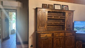 Un meuble en bois doté de nombreux tiroirs et d’étagères, un téléviseur sur la droite et un certificat encadré placé sur le dessus.