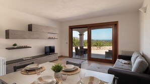 Una cucina moderna con zona pranzo, TV e vista sull'esterno.