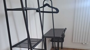 A bunk bed with a desk and chair, a radiator, and wooden flooring.