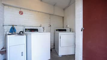 Een wasserette met twee wasmachines en een rookvrij-bord aan de muur.
