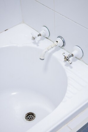 A white bathtub with two faucets and a drain. - Bright Bondi Beach Studio (Bondi Beach)