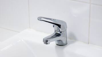 Ein weißes Waschbecken mit chromfarbenem Wasserhahn.