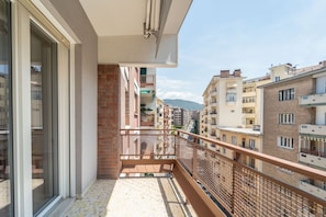 A balcony with a view of neighboring buildings and a mountain in the distance. - A comfortable and welcoming 50 square meters apartment, perfect for four people, located on the sixth floor of a building with an elevator (NOT accessible to people with disabilities).The property is situated in a quiet area not far from the center of Tr (Trieste)