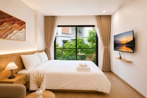 A hotel room with a bed, a nightstand, a lamp, a TV, and a view of greenery outside. - Nice apartment with AC in vibrant Hà Nội city center (Hà Nội)