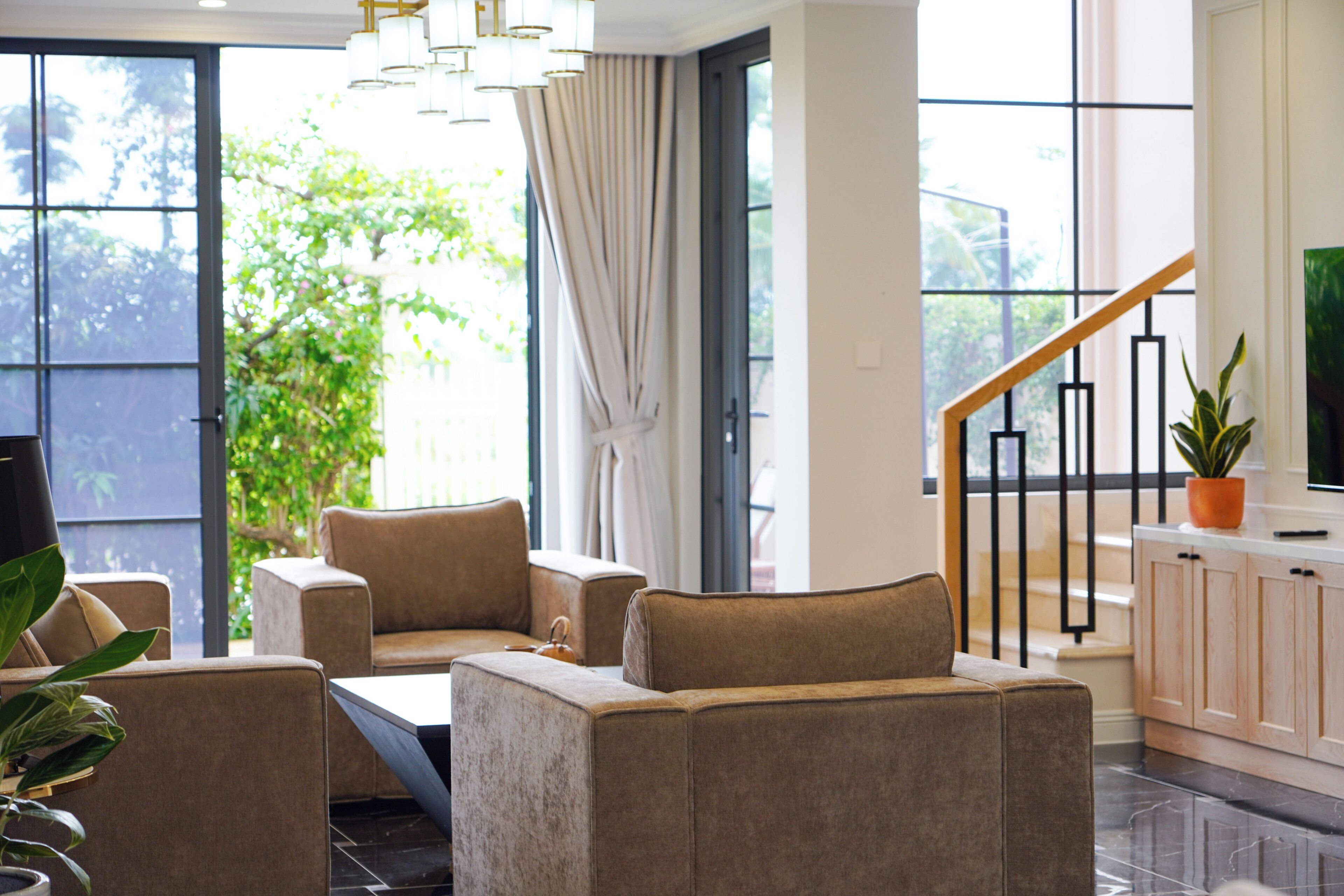 A modern living room with sofas, a coffee table, a TV, and a staircase leading to an upper level.