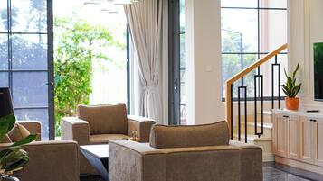 A modern living room with sofas, a coffee table, a TV, and a staircase leading to an upper level.