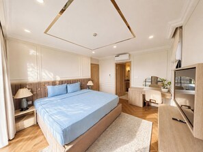 Un dormitorio moderno con una cama grande, mesitas de noche, un escritorio y una televisión.