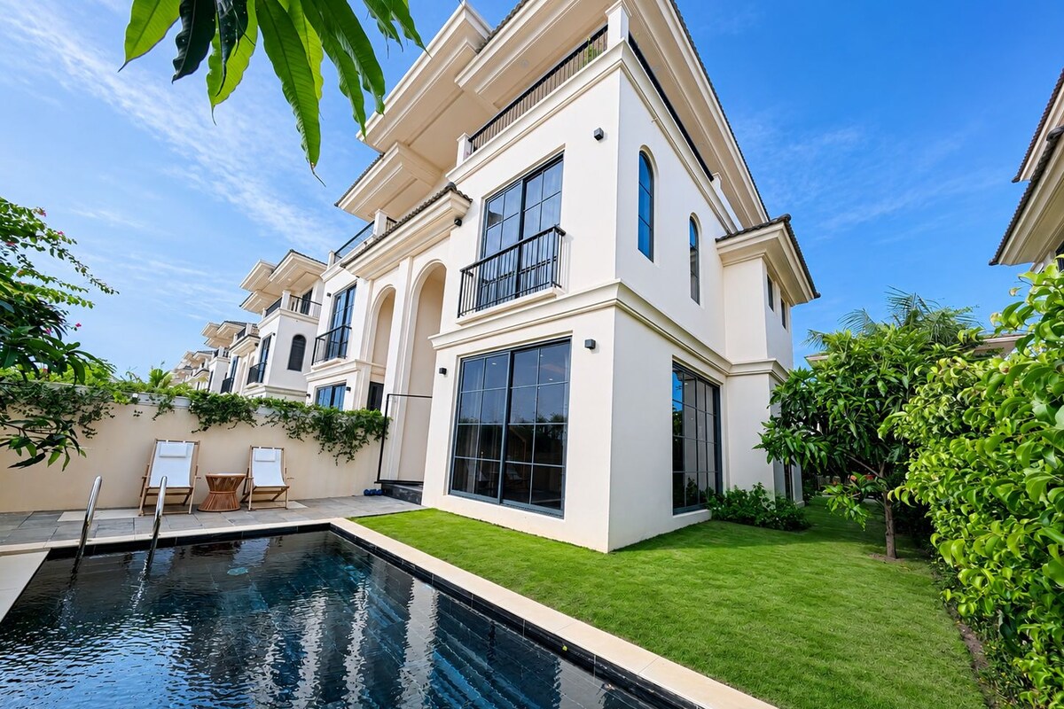 Una casa moderna de dos pisos con piscina, ventanas amplias y césped bien cuidado.