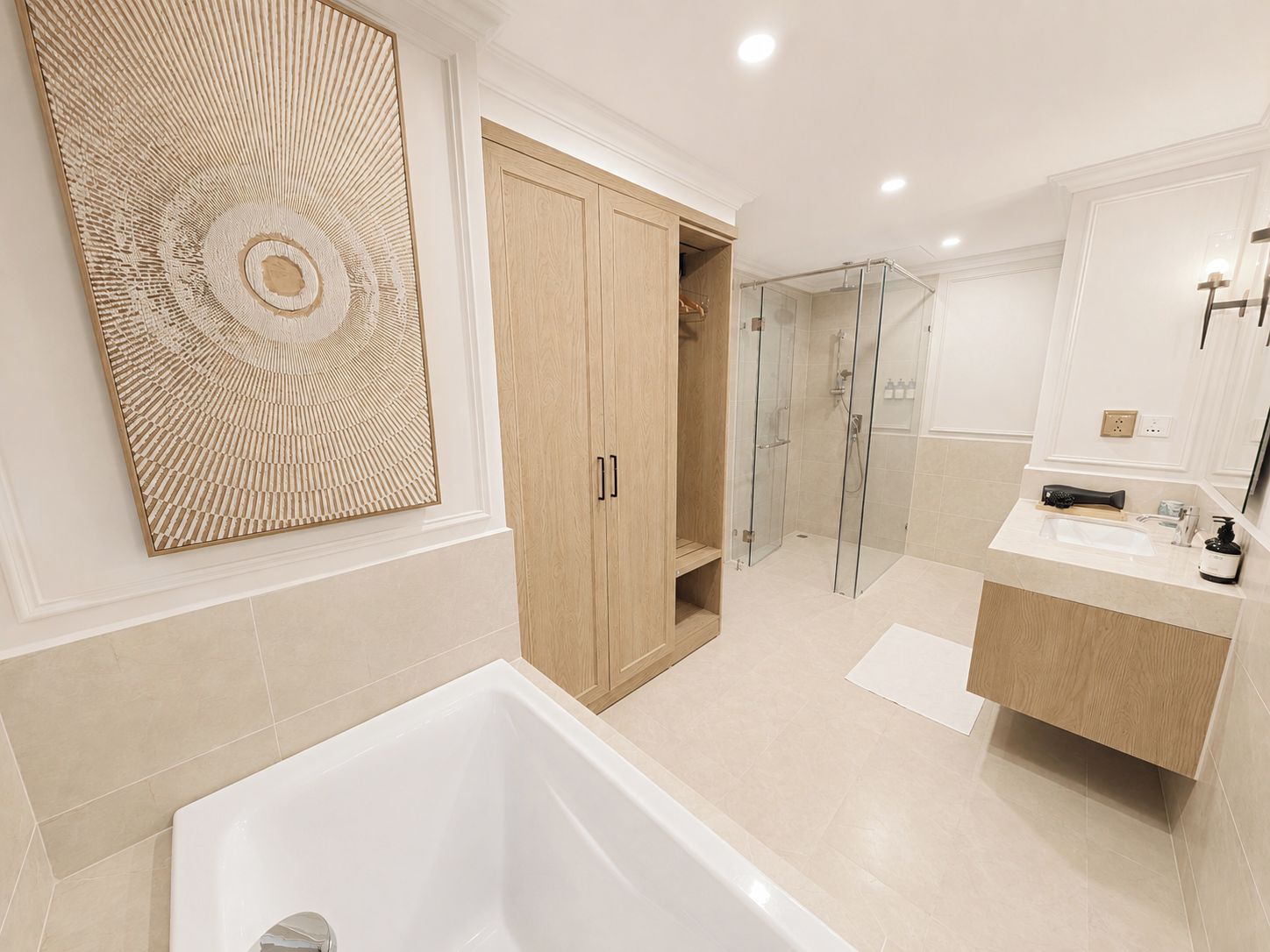 A modern bathroom with a bathtub, a glass shower enclosure, and wooden cabinets.