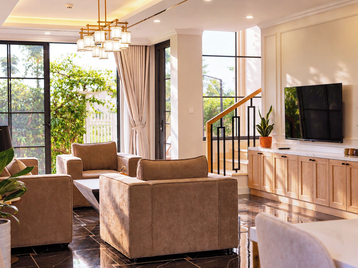 A modern living room with a sofa set, a television, and a staircase leading to an upper level.