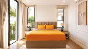A spacious bedroom with a large bed, two bedside tables, and a view of greenery outside.
