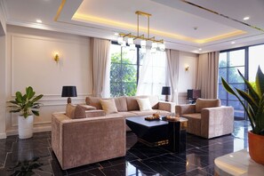 Una sala moderna con un sofá modular, una mesa de centro y un ventanal con cortinas.