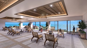 A spacious indoor area with multiple seating arrangements, large windows offering a view of the sea, and a ceiling with a unique geometric design. - Solmera Beach Park Resort (San Juan)