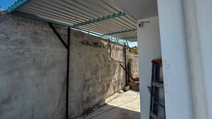 Una obra en construcción con un edificio parcialmente levantado, paredes de concreto expuesto y estructura de techo metálica.
