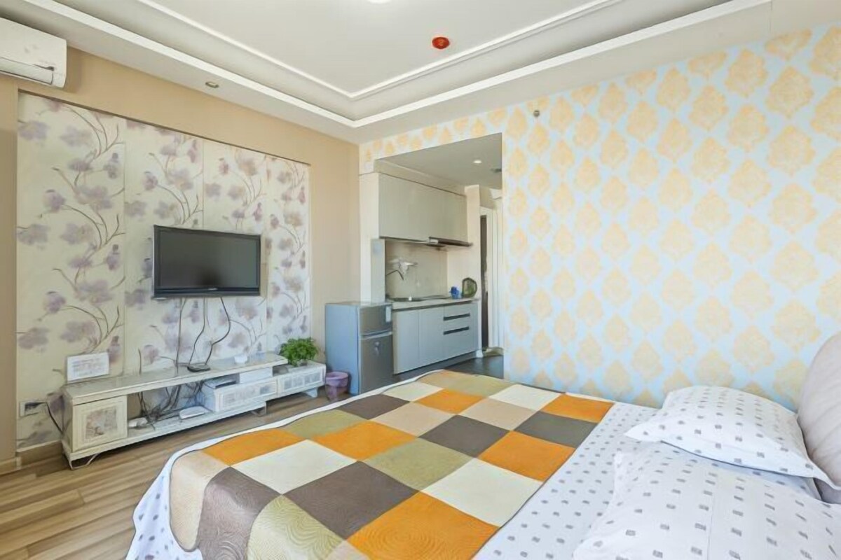 Una habitación de hotel con cama, televisión, escritorio y espejo.
