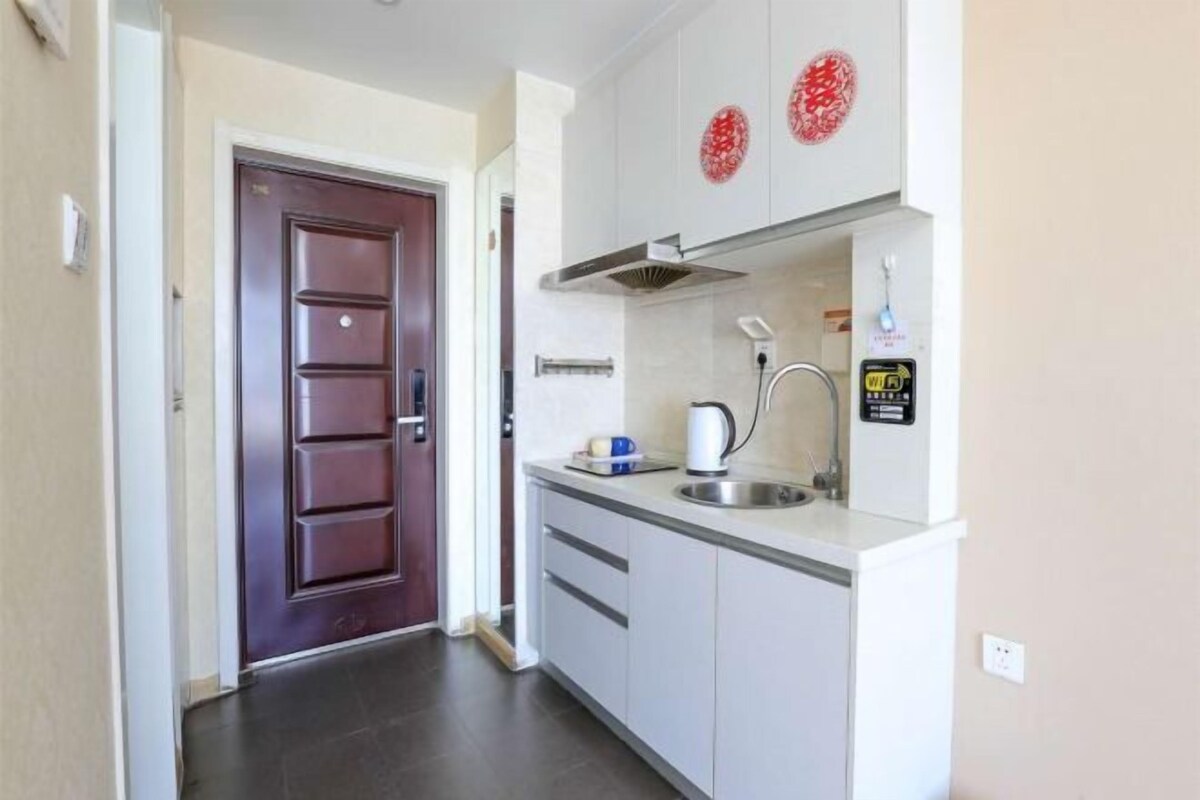 Una cocina compacta con estufa integrada, lavamanos y microondas.