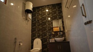 Une salle de bain comprenant des toilettes, un lavabo, un miroir et une douche.