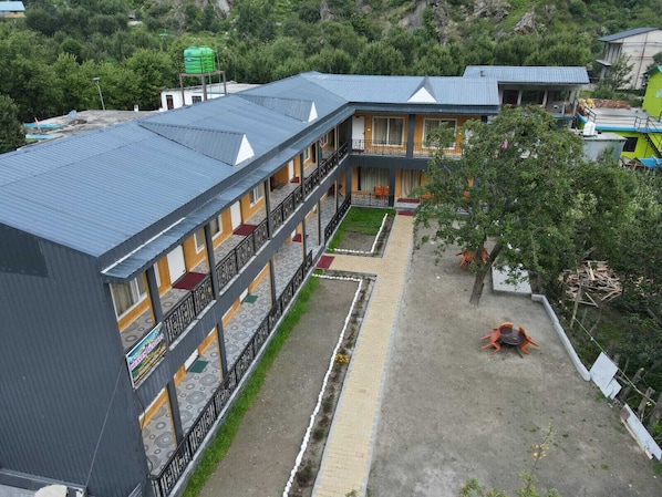 Un hotel de varios pisos con patio, balcones y un tanque de agua.