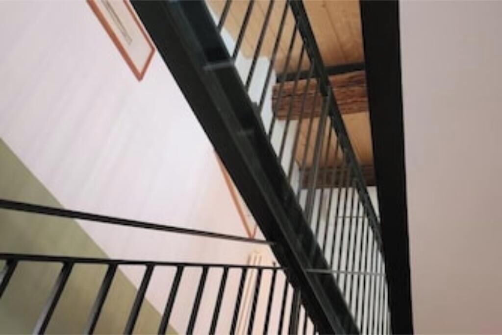 A staircase with metal railings and a wooden handrail.