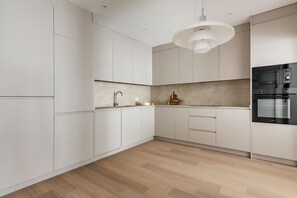 Eine moderne Küche mit weißen Schränken, einer Holz Arbeitsplatte und integrierten Geräten.