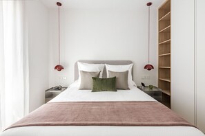 A bedroom with a bed, bedside tables, a nightstand, a wooden wardrobe, and pendant lights. - Brightness and Comfort in Madrid (Madrid)