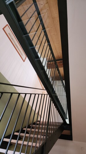 A staircase with a wooden handrail and metal balusters. - Bright apartment in the heart of Vicenza with a view of the Basilica Palladiana (Vicenza)