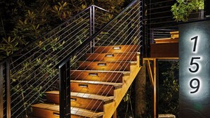 A modern staircase with metal railings, wooden steps, and a sign indicating the building number 159. - Mirror house wellness retreat: private sauna, hot tub, spring-fed cold plunge & your own waterfall. Tucked on 35 acres along the French Broad River, minutes from Brevard breweries, Pisgah & DuPont. (Pisgah Forest)