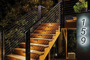 Eine moderne Treppe mit Metallgeländern, Holzhäuschen und einem Schild mit der Hausnummer 159.