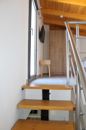 Ein modernes Interieur mit einer Holztreppe, einem kleinen Holztisch und einem Kleiderschrank.