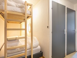 A bunk bed with a ladder, a grey door, and a small window. - Studio with a balcony and a view of the mountains (Saint-Sorlin-d´Arves)