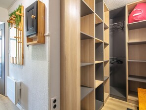 A walk-in closet with open shelving, a radiator, and a hanging rod. - Studio with a balcony and a view of the mountains (Saint-Sorlin-d´Arves)