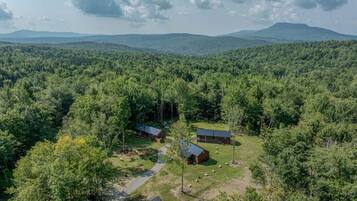 A forested area with a cabin and a barn.