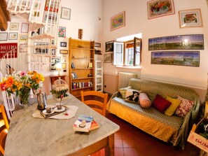 A cozy living room with a dining table, a sofa, and a bookshelf. - Le Piane by Interhome (Lucca)