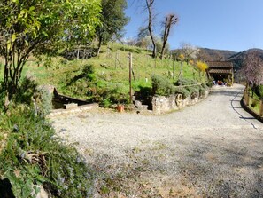 A gravel path leading to a traditional building with a tiled roof, surrounded by greenery and hills in the background. - Le Piane by Interhome (Lucca)