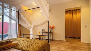 Ein Schlafzimmer mit einem Bett, einem Schreibtisch, einem Stuhl und einem Fenster mit Vorhängen.