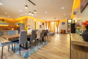 A modern kitchen with built-in appliances and a dining area with a wooden table and chairs.