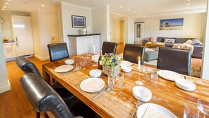 A dining area with a wooden table set for six, surrounded by black chairs. - Feuerstein Family Home, Apartment 4 (Wangerooge)
