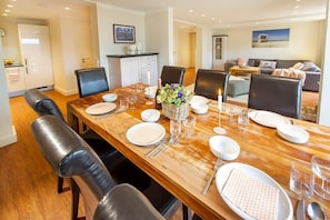 A dining area with a wooden table set for six, surrounded by black chairs. - Feuerstein Family Home, Apartment 4 (Wangerooge)
