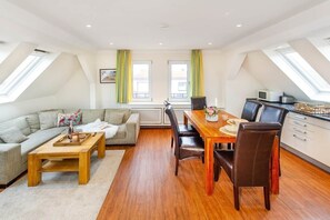 Eine moderne Loftwohnung mit Essbereich, Küche und Wohnbereich.
