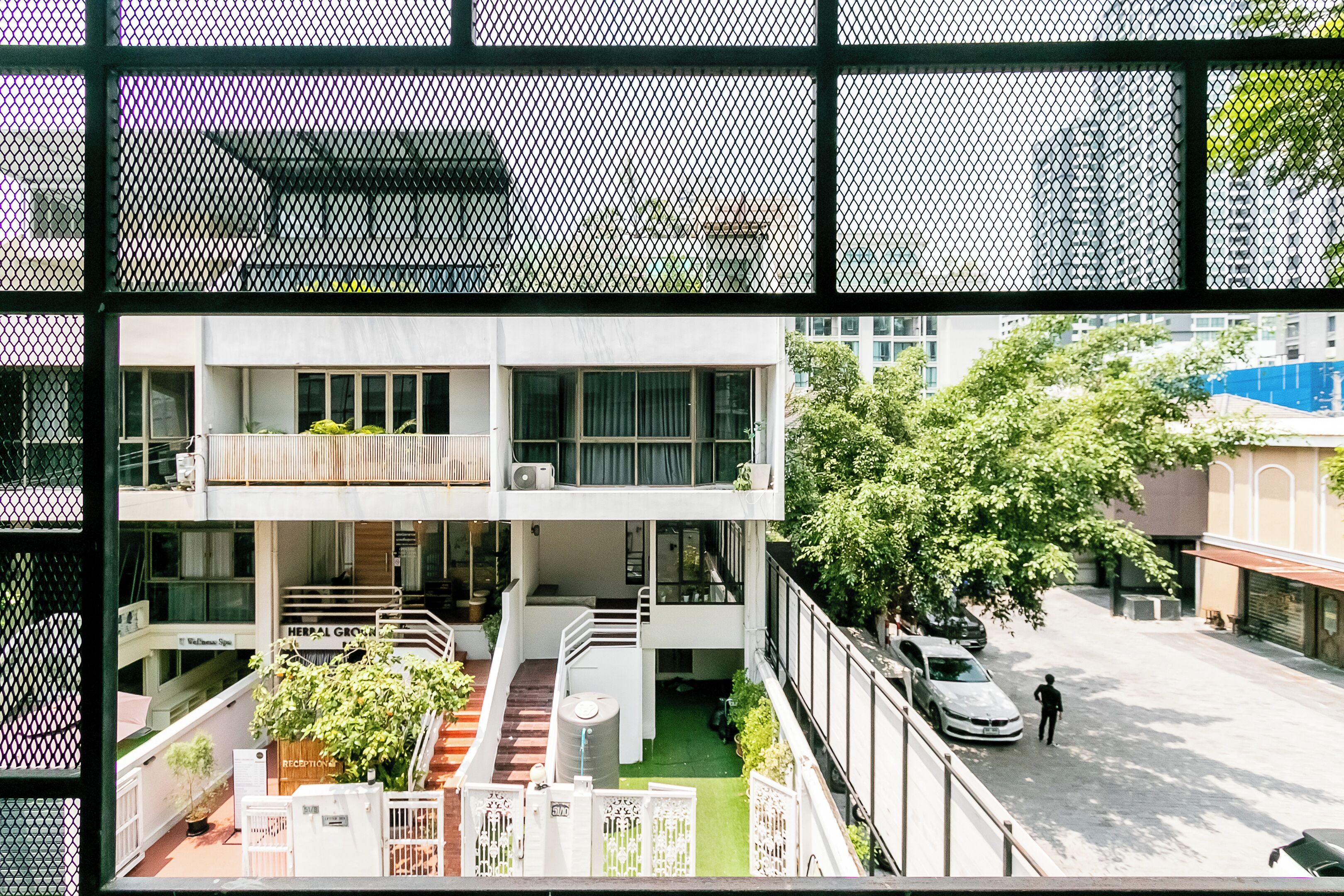 Un immeuble à plusieurs étages comprenant un espace d’accueil, des sièges à l’extérieur et un escalier menant aux étages supérieurs.