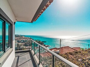 A balcony with a glass railing overlooking a coastal view. - Camara de Lobos Lux by Interhome (Câmara de Lobos (Madeira))