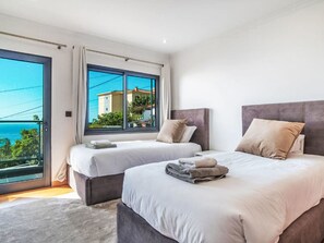 Een hotelkamer met twee bedden, een groot raam met uitzicht en een balkon.