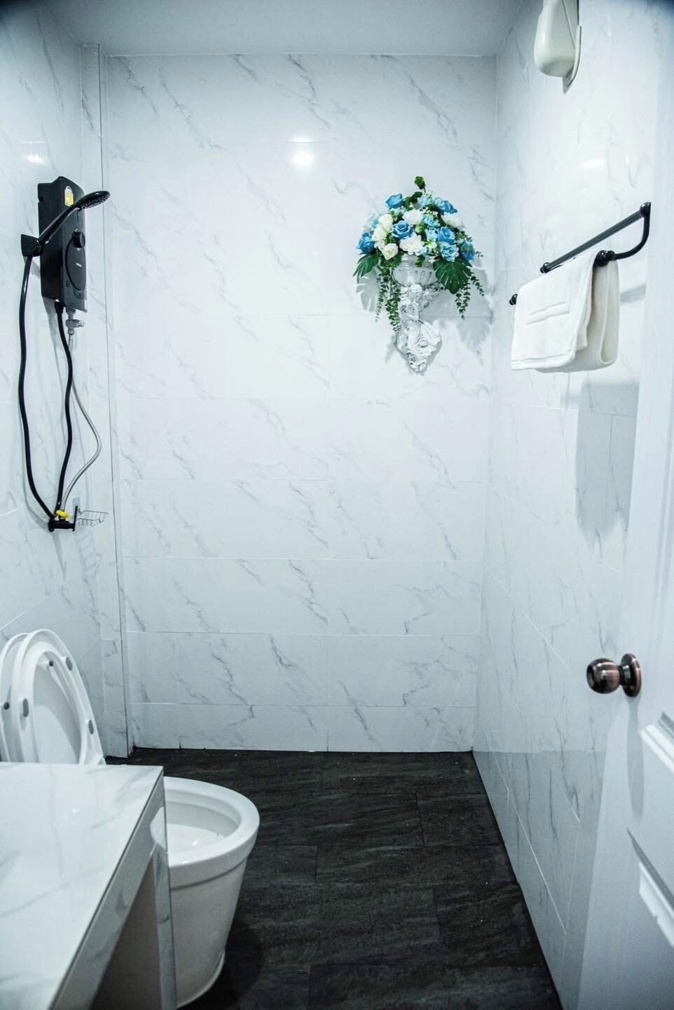 A bathroom with a toilet, a shower, and a sink.