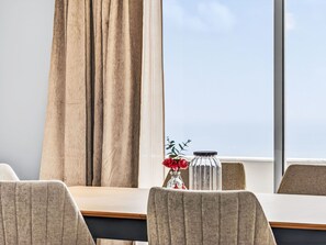 A room with a large window, a table, and two chairs. - Calheta Artlantic Pearl by Interhome (Calheta (Madeira))