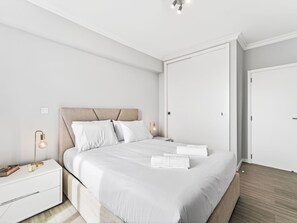 A modern bedroom with a bed, bedside tables, and a wardrobe. - Calheta Artlantic Pearl by Interhome (Calheta (Madeira))
