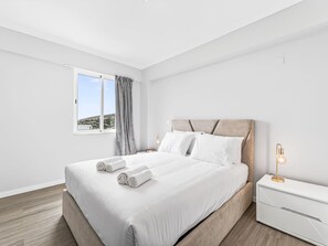 A modern hotel room with a large bed, a bedside table, and a window with a view of the landscape. - Calheta Artlantic Pearl by Interhome (Calheta (Madeira))