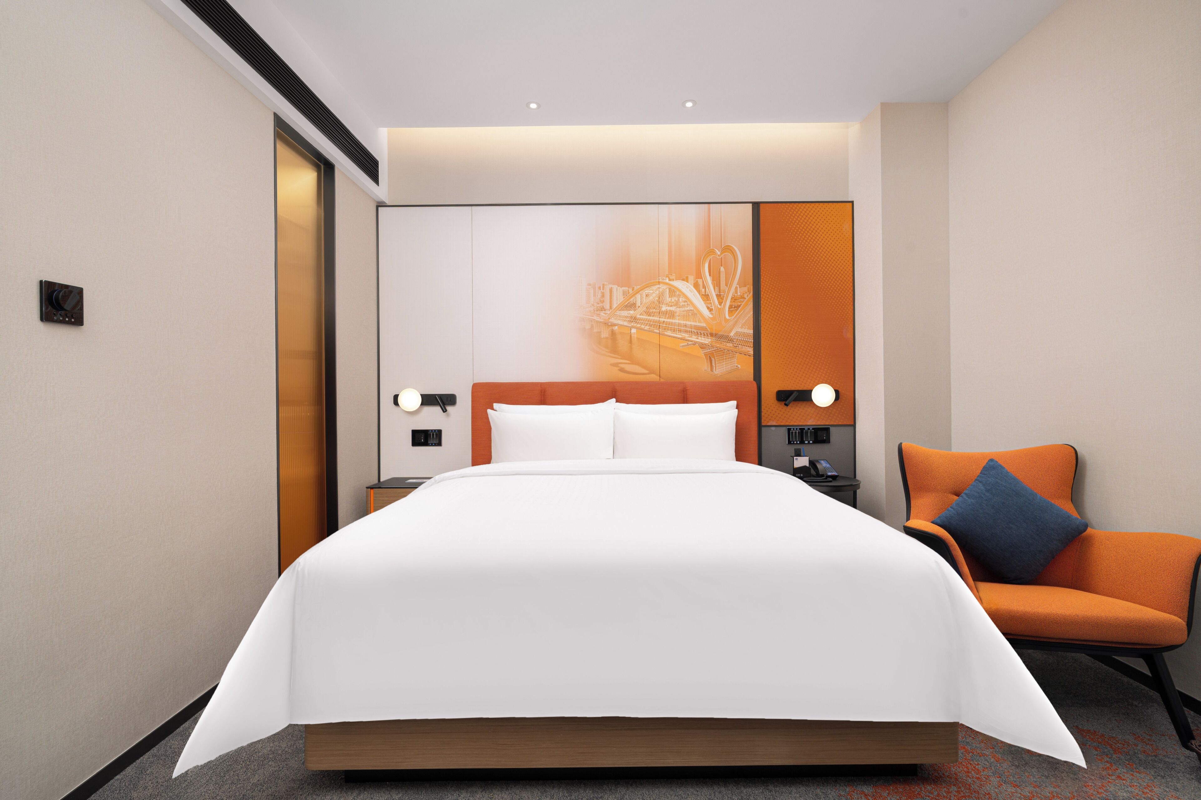 A hotel room with a large bed, a nightstand, a chair, and a wall-mounted TV.