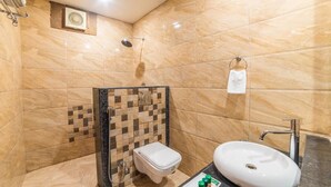 A bathroom with a shower, toilet, sink, and towel rack. - Hotel JS Jodhpur (Jodhpur)