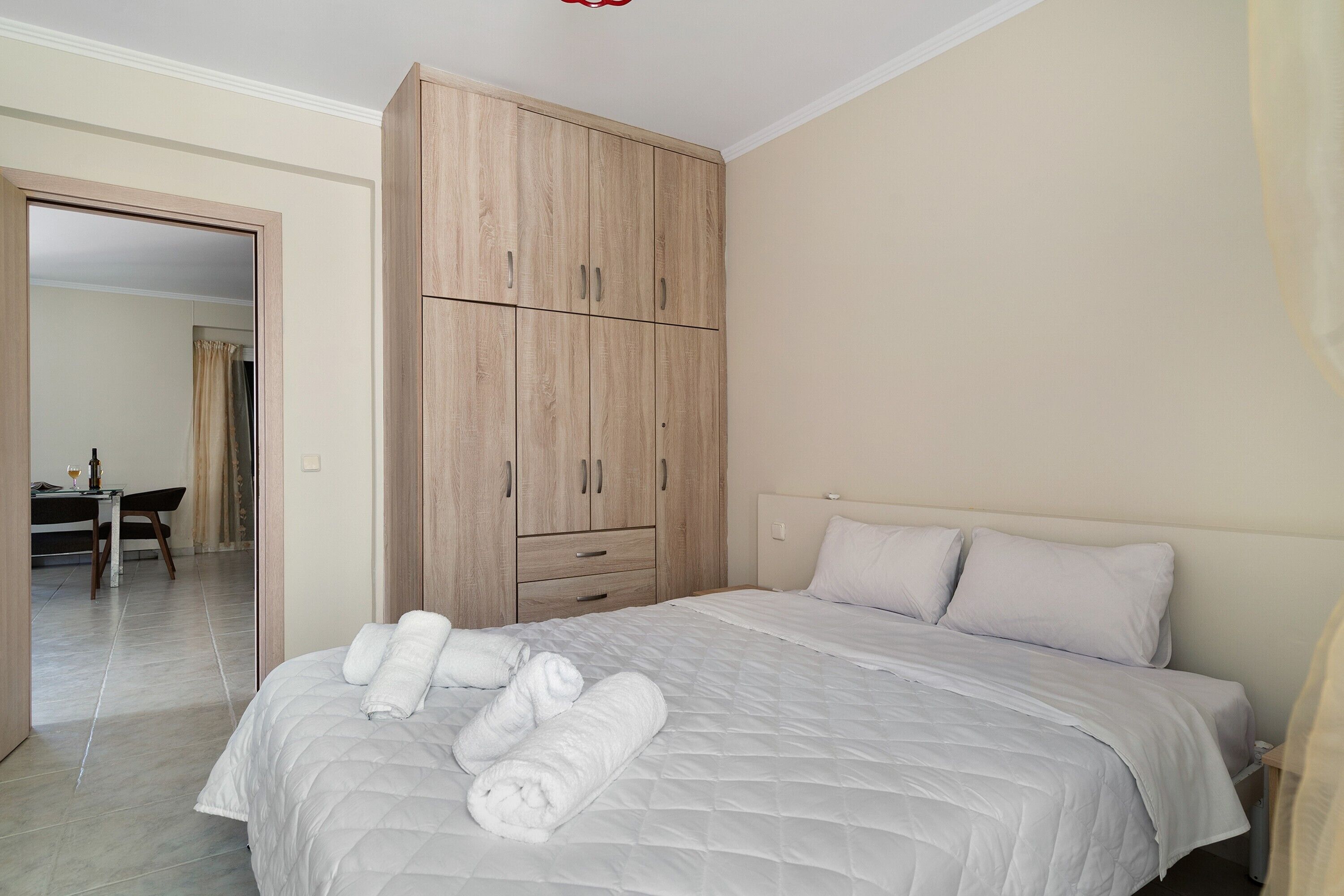 Un dormitorio con cama, armario y baño al fondo.
