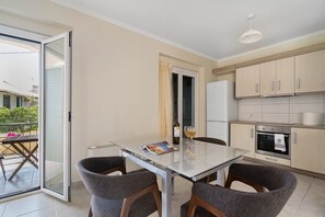 Eine moderne Küche mit Esstisch, Stühlen und einem Kühlschrank.